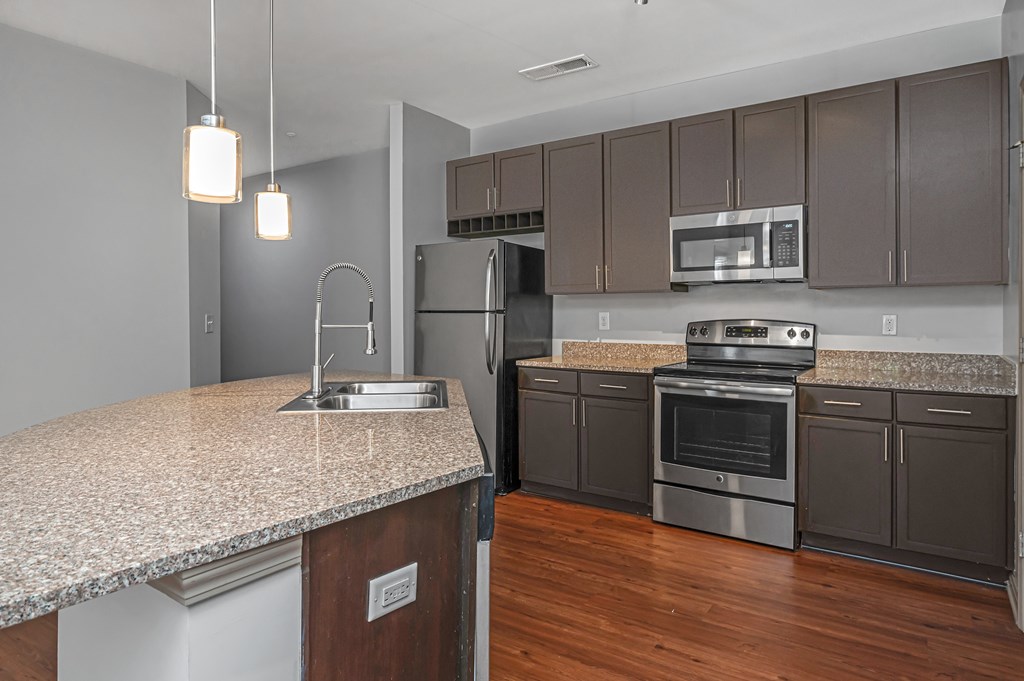 A kitchen with a granite countertop and stainless steel appliances.